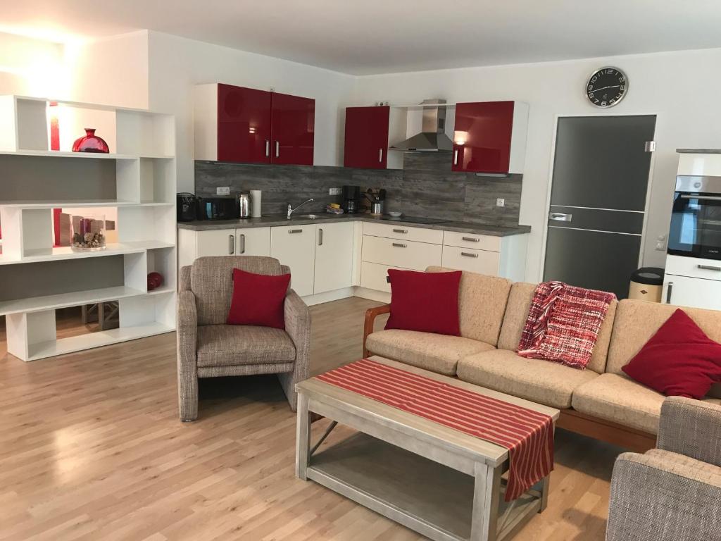 a living room with a couch and two chairs and a kitchen at ruhige Souterrainwohnung in Leverkusen