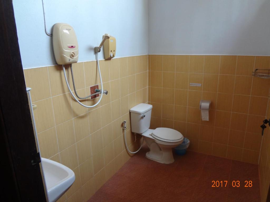 een badkamer met een wit toilet en een douche bij At Home Sukhothai in Sukhothai
