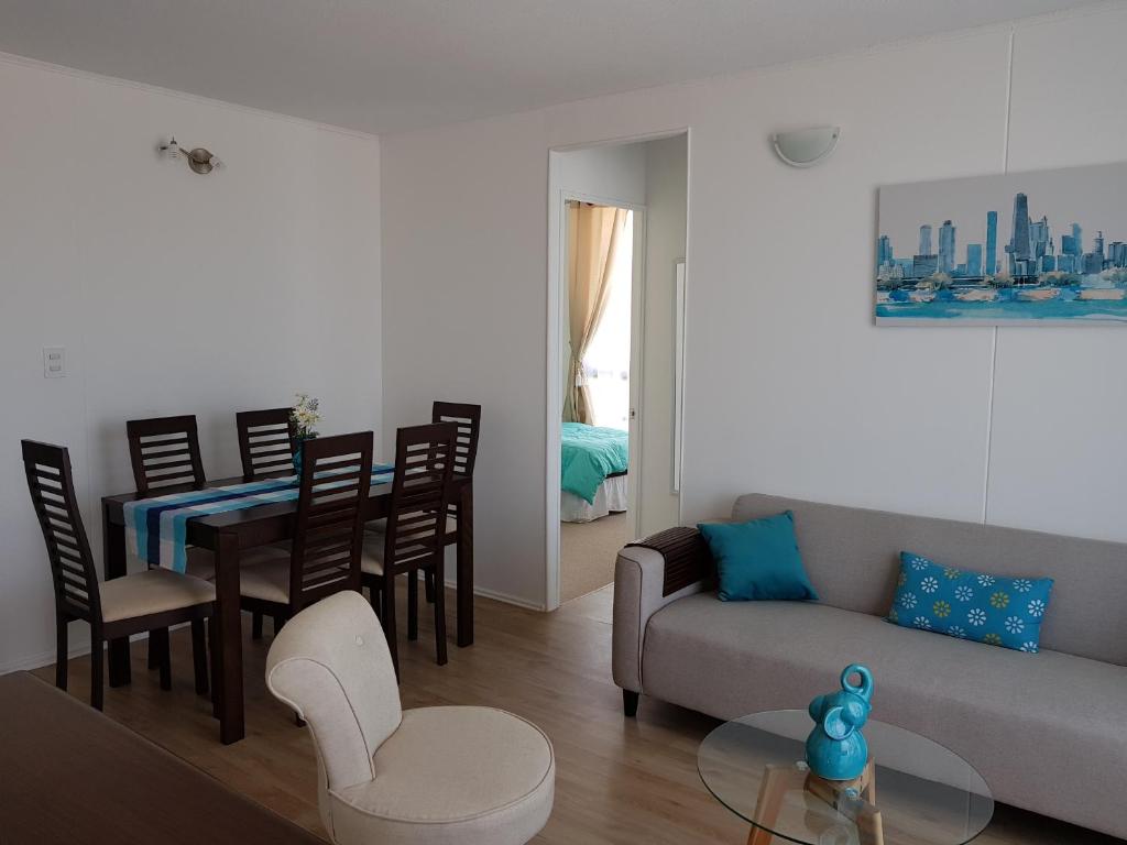 ein Wohnzimmer mit einem Sofa und einem Tisch in der Unterkunft PUQ Rent Apartment in La Serena