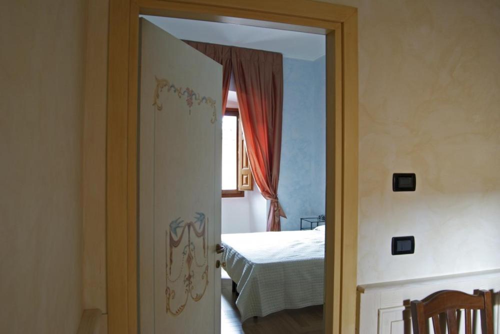 una porta aperta che conduce a una camera con letto di B&B Palazzo Cappa a L'Aquila