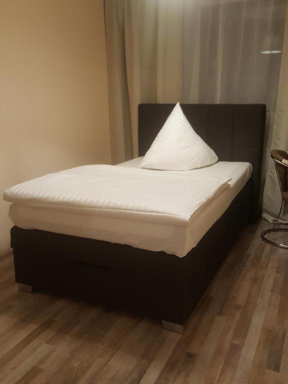 a bed with a pillow on top of it at Hotel-Residenz Oberurseler Hof in Oberursel