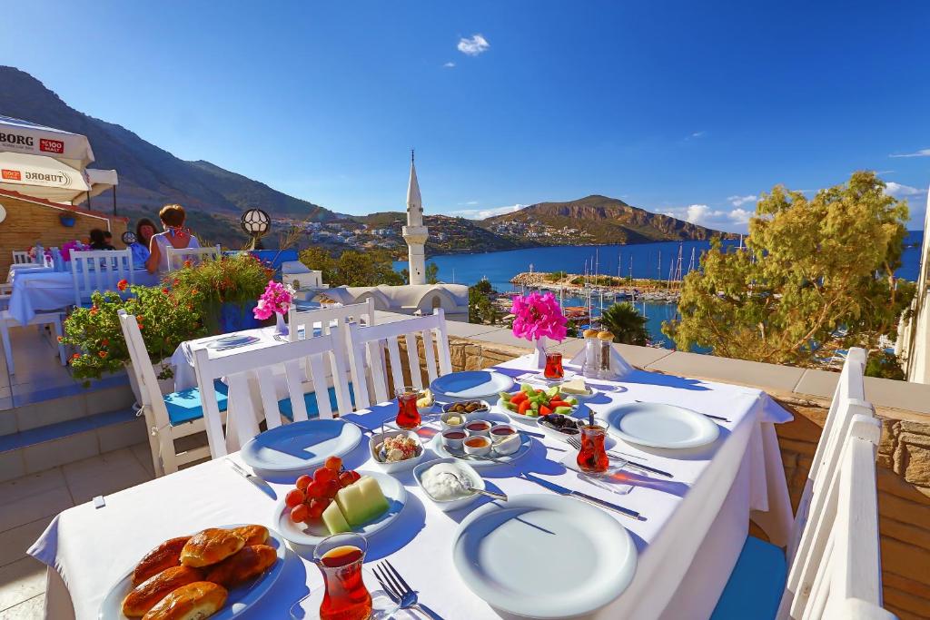 a table with plates of food on top of a balcony at Zinbad Hotel Kalkan in Kalkan