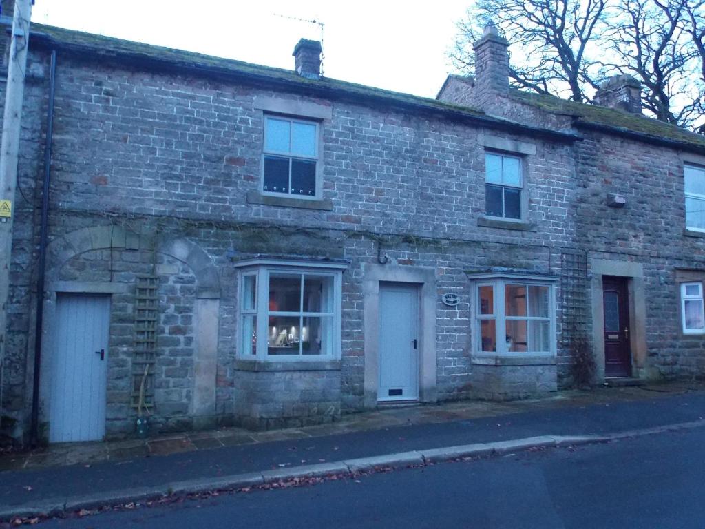 an old brick building with two doors and a window at Hilltop Cottage, Barnard Castle in Barnard Castle