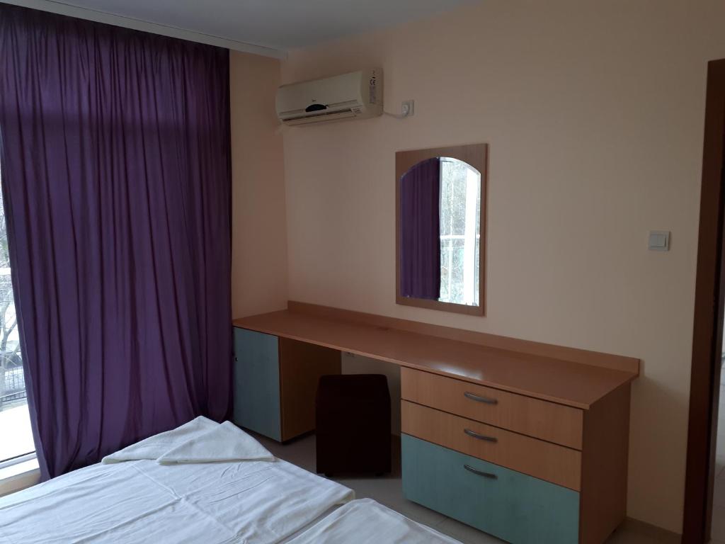 a bedroom with a bed and a desk and a window at Apart Hotel Ravda in Ravda