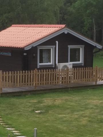 ein kleines Haus mit einem Holzzaun im Hof in der Unterkunft Lammsjon Relax in Sille