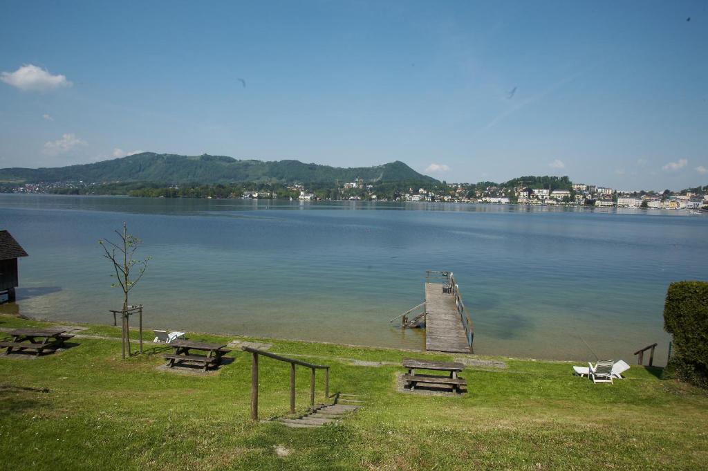 ein Dock in der Mitte eines Sees mit Picknicktischen in der Unterkunft Ferienwohnung Haselberger in Gmunden