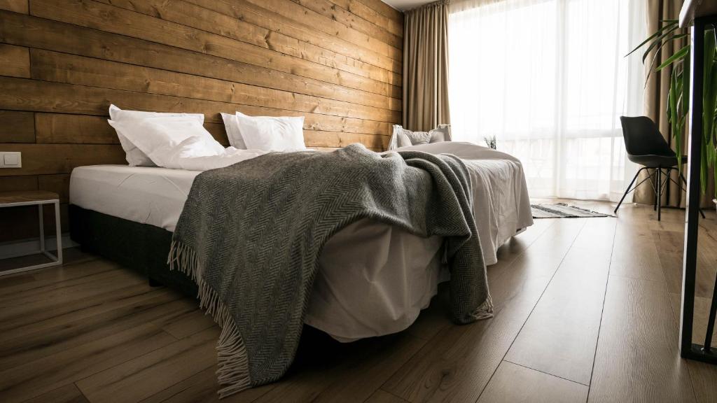 1 dormitorio con 1 cama con pared de madera en The Mint Hotel - Saint Vlas en Sveti Vlas