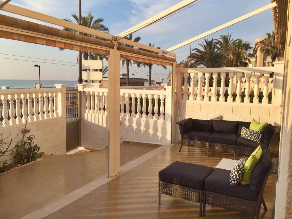 d'une terrasse avec deux canapés et d'un balcon donnant sur l'océan. dans l'établissement Beach Front Ground Floor Flat Playa San Juan, à El Campello