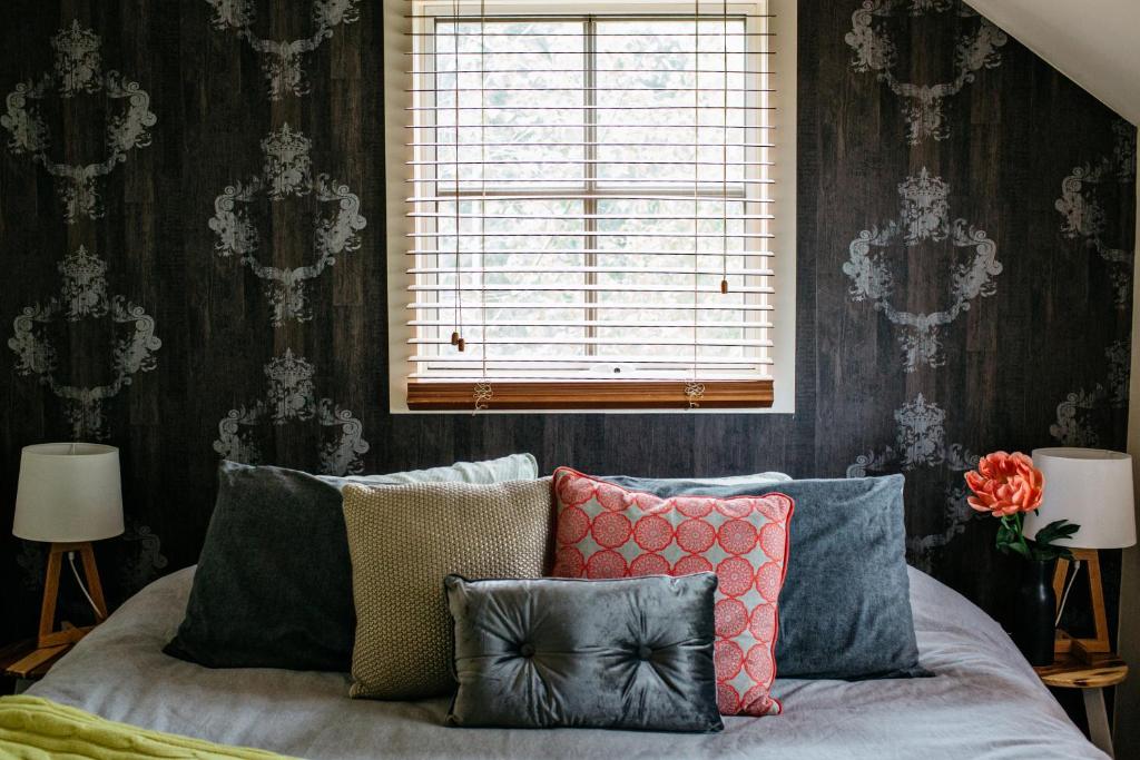 a room with a couch with pillows and a window at Northfield Boutique Apartments in Woodend