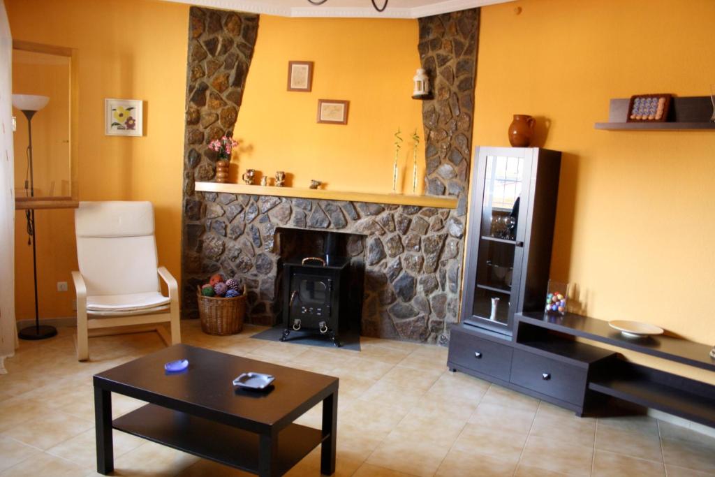 sala de estar con chimenea de piedra y piano en El Rincón del Violinista, en Cuenca
