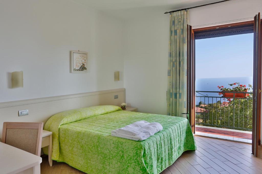 a bedroom with a green bed and a balcony at BB Santalucia in Agerola