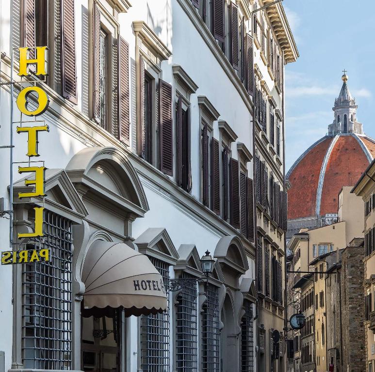 un edificio con un cartel de hotel en una calle de la ciudad en Hotel Paris en Florencia