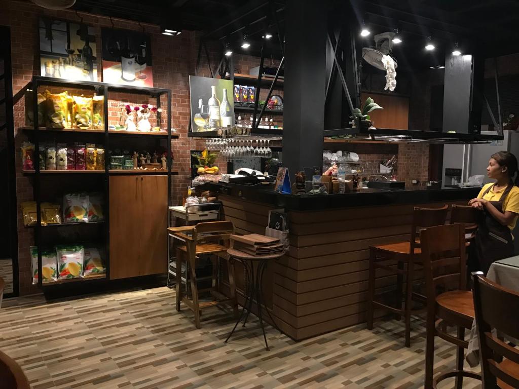a woman standing at a bar in a restaurant at David Residence in Nai Yang Beach