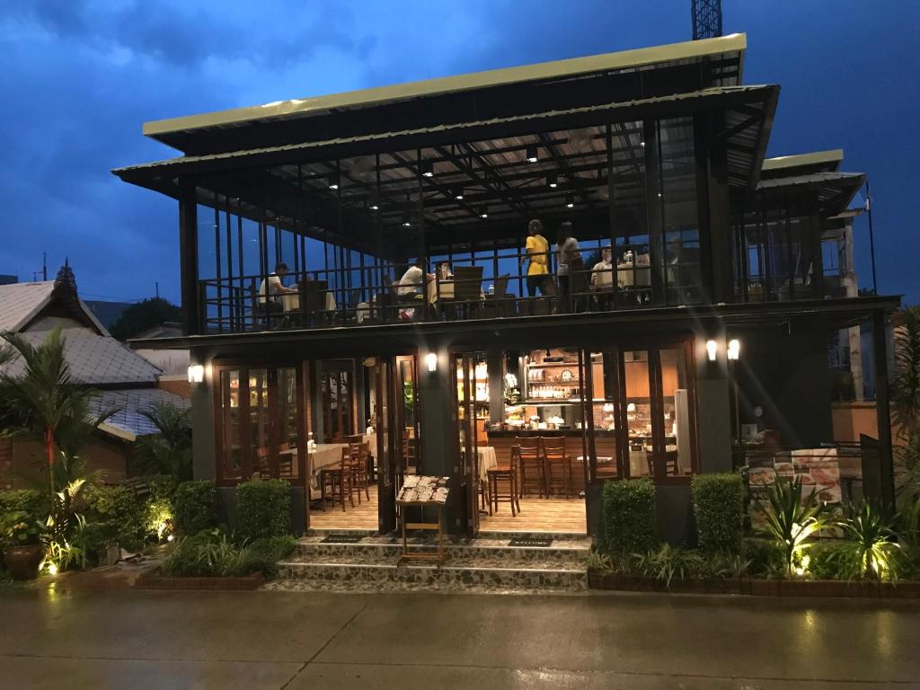 a house with people sitting on the balcony at night at David Residence in Nai Yang Beach