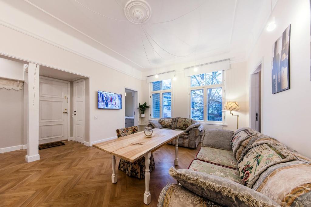een woonkamer met een bank en een tafel bij Modern History Apartment in Tallinn