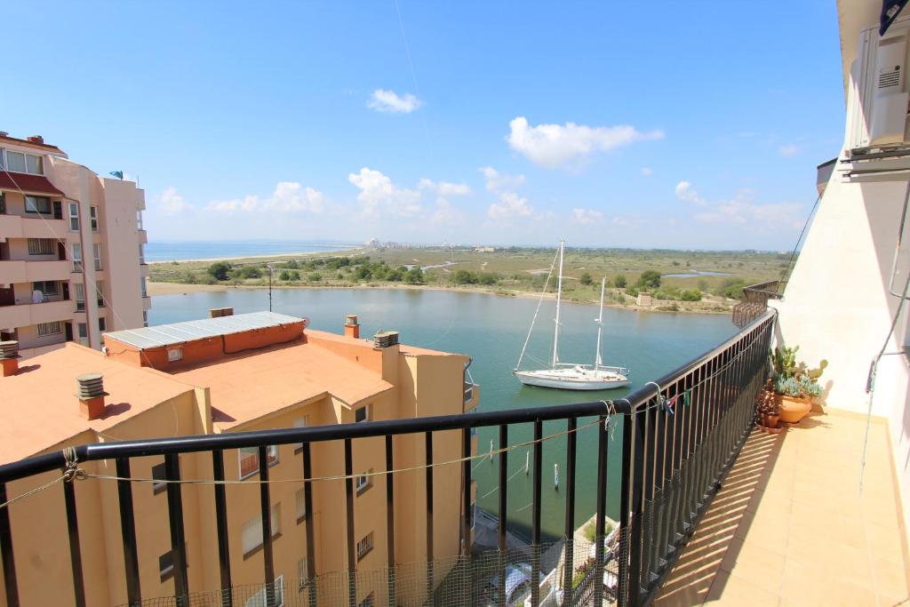 ein Segelboot im Wasser auf einem Fluss mit Gebäuden in der Unterkunft LEON INMO Apartment Bellevue - 10487 in Empuriabrava