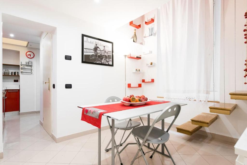 a kitchen with a white table and chairs and a red table at Major sisters, holiday home in the heart of Rome in Rome