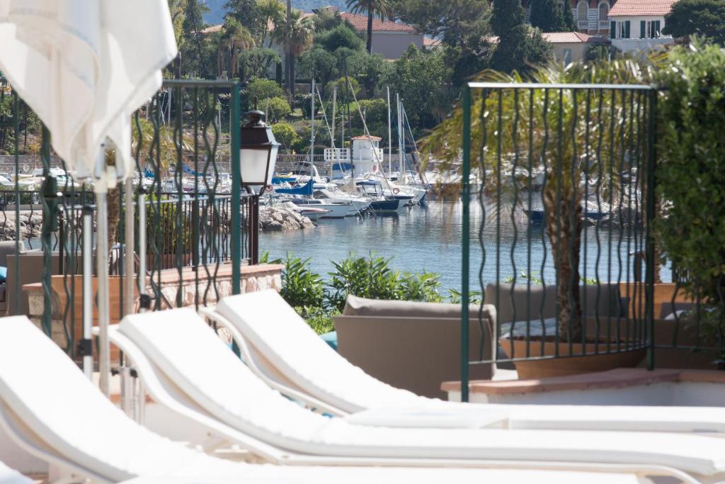 a group of white chairs sitting next to a marina at Hotel Royal-Riviera in Saint-Jean-Cap-Ferrat