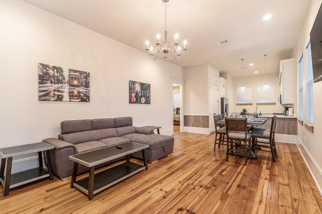 una sala de estar con un sofá y una mesa en Hosteeva 3 BR Cottage Close to St Charles 5 m Ride to FQ, en Nueva Orleans