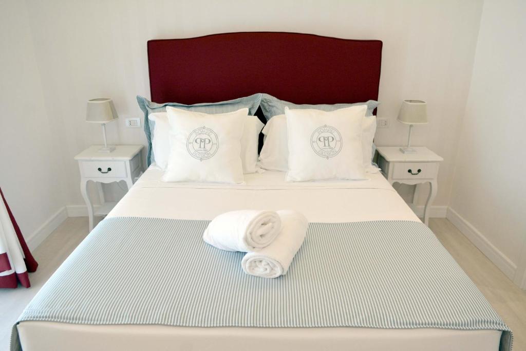 een bed met twee kussens en een handdoek erop bij B&B Pompei Passion in Pompei