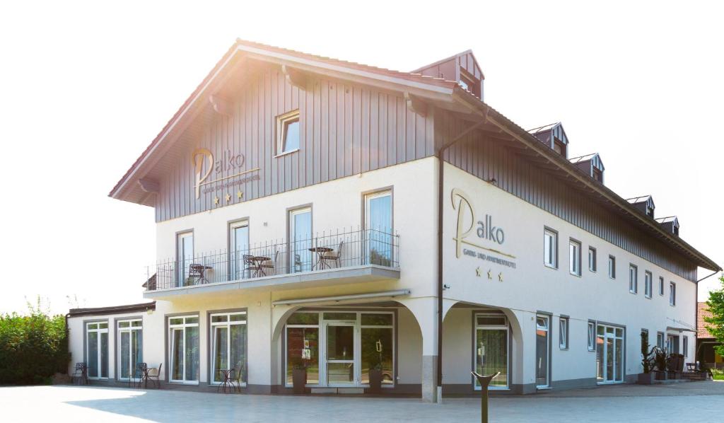 a white building with a balcony on the side of it at Hotel Palko in Dingolfing