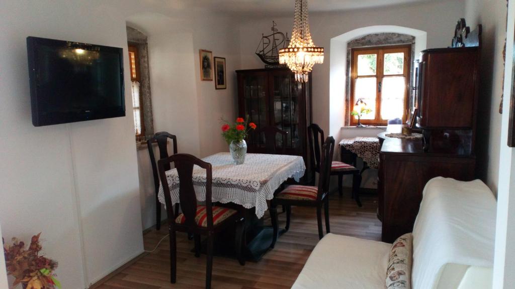 jadalnia ze stołem i krzesłami oraz telewizorem w obiekcie Apartments Camellia & Magnolia w mieście Volosko