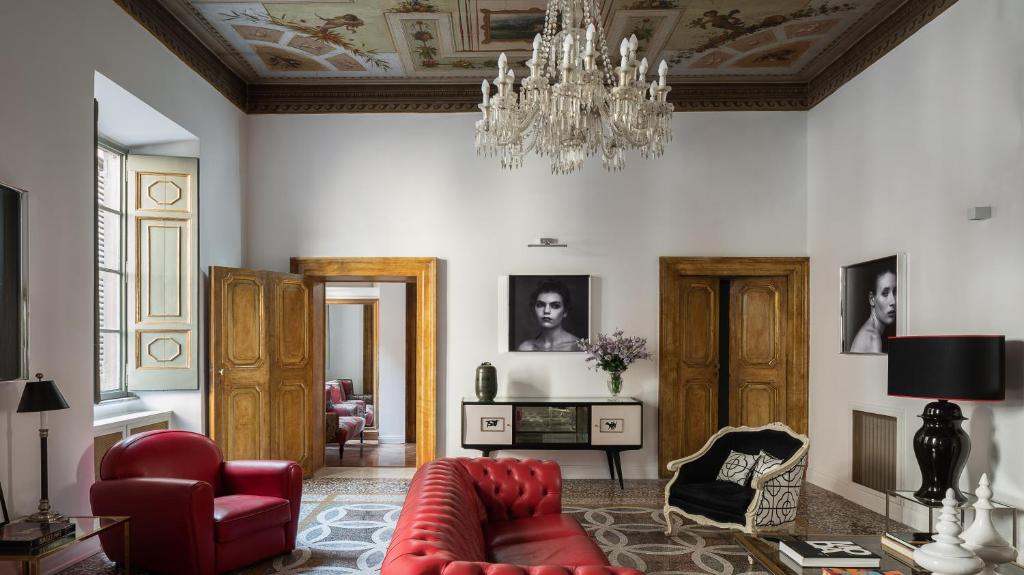a living room with a red couch and a chandelier at Nobildonne Relais in Rome