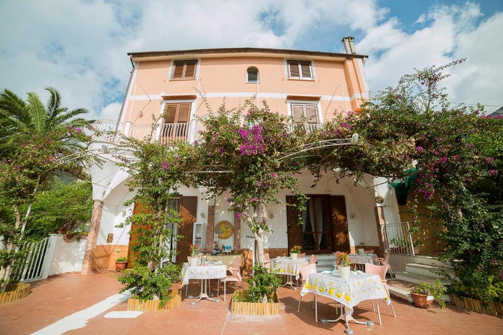 a pink building with tables and chairs in front of it at B&B Bouganville in Tramonti
