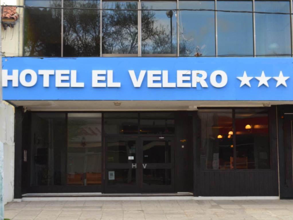un cartel de hotel el vallecano frente a un edificio en Hotel El Velero, en Villa Gesell