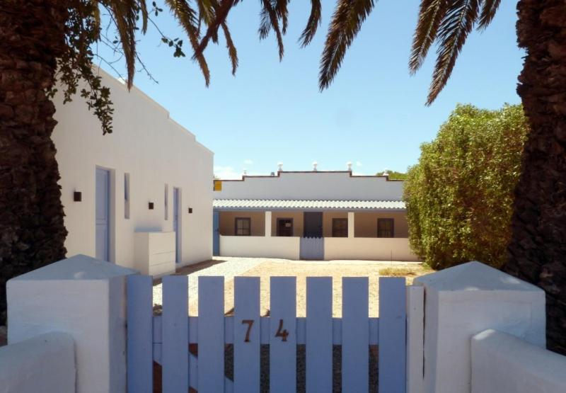 a white fence in front of a white building at Old Fisher House in Langebaan