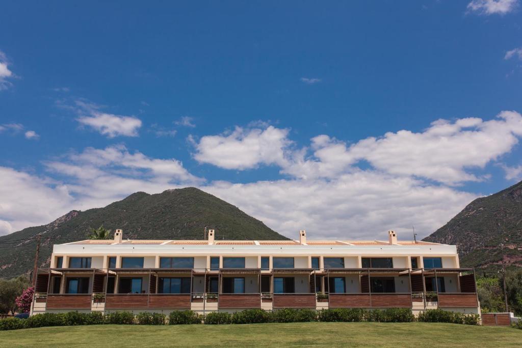 a building with mountains in the background at Melimar Homes By The Sea in Marathias