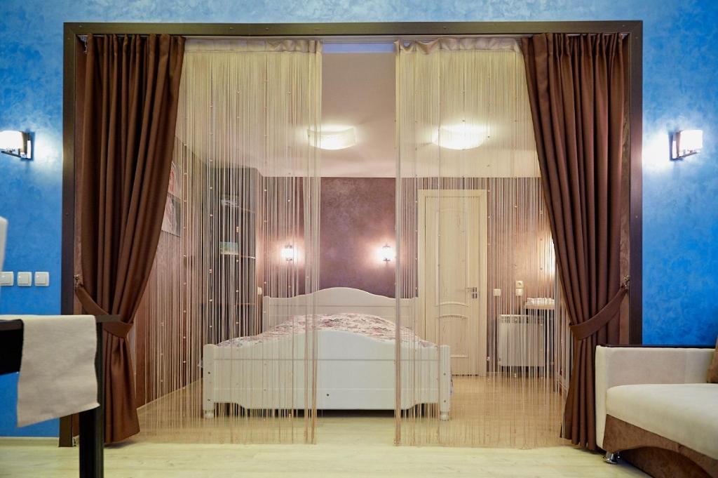 um quarto com uma cama e uma parede de vidro em Idillia Mini Hotel em Velikiye Luki