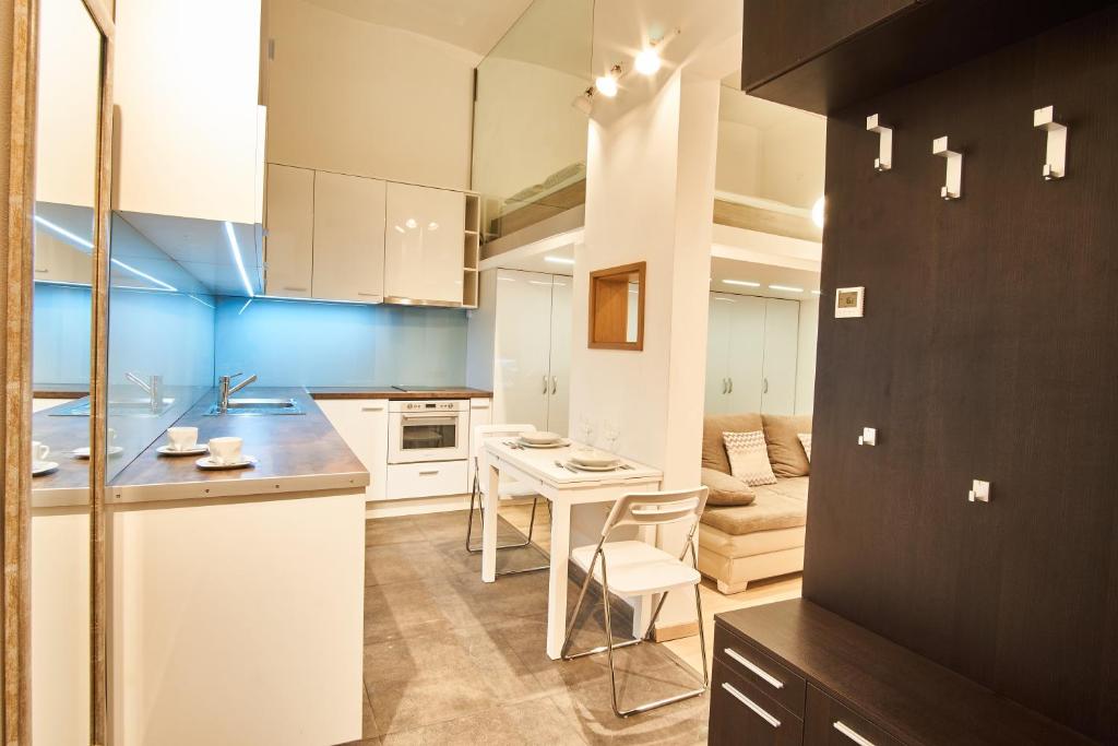 eine Küche und ein Wohnzimmer mit einem Tisch und Stühlen in der Unterkunft V27 Apartment | hostAID in Budapest