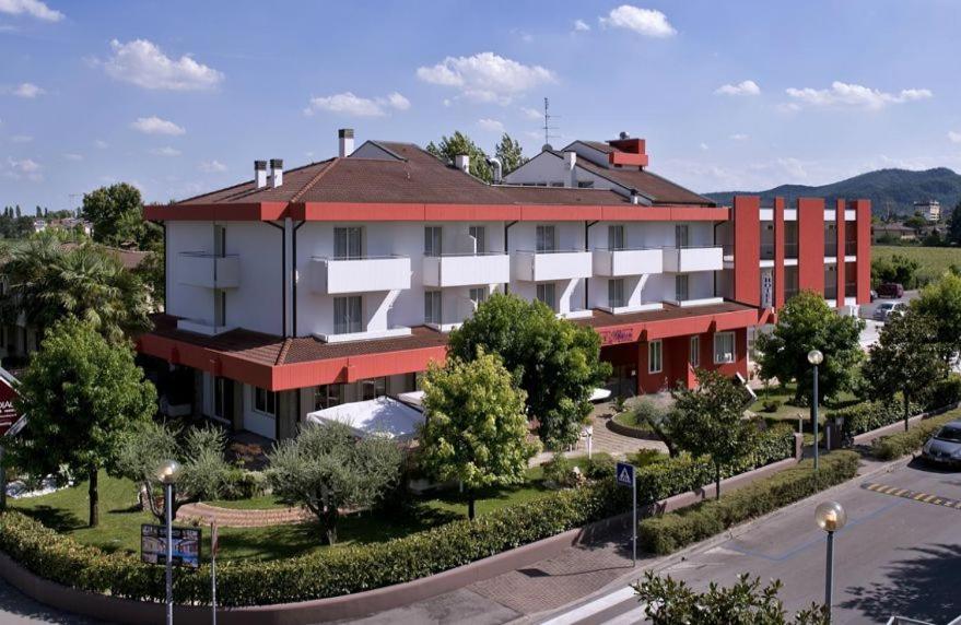 un gran edificio rojo y blanco en una calle en Hotel Lo Zodiaco, en Abano Terme