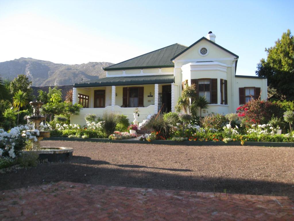 a white house with a garden in front of it at Kingna Lodge Montagu in Montagu