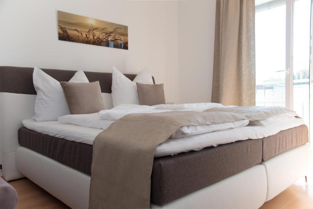 1 dormitorio con 1 cama grande con almohadas blancas en Das Eberhart, en Köflach