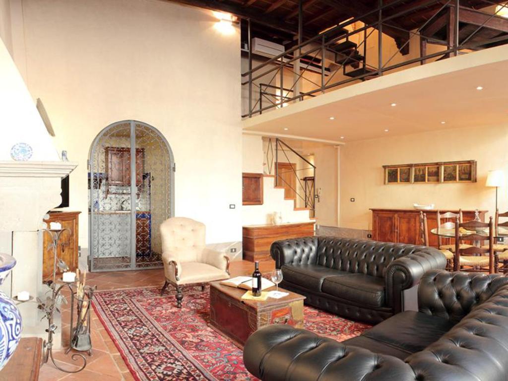 un soggiorno con divano in pelle e tavolo di Apartment Tornabuoni a Firenze