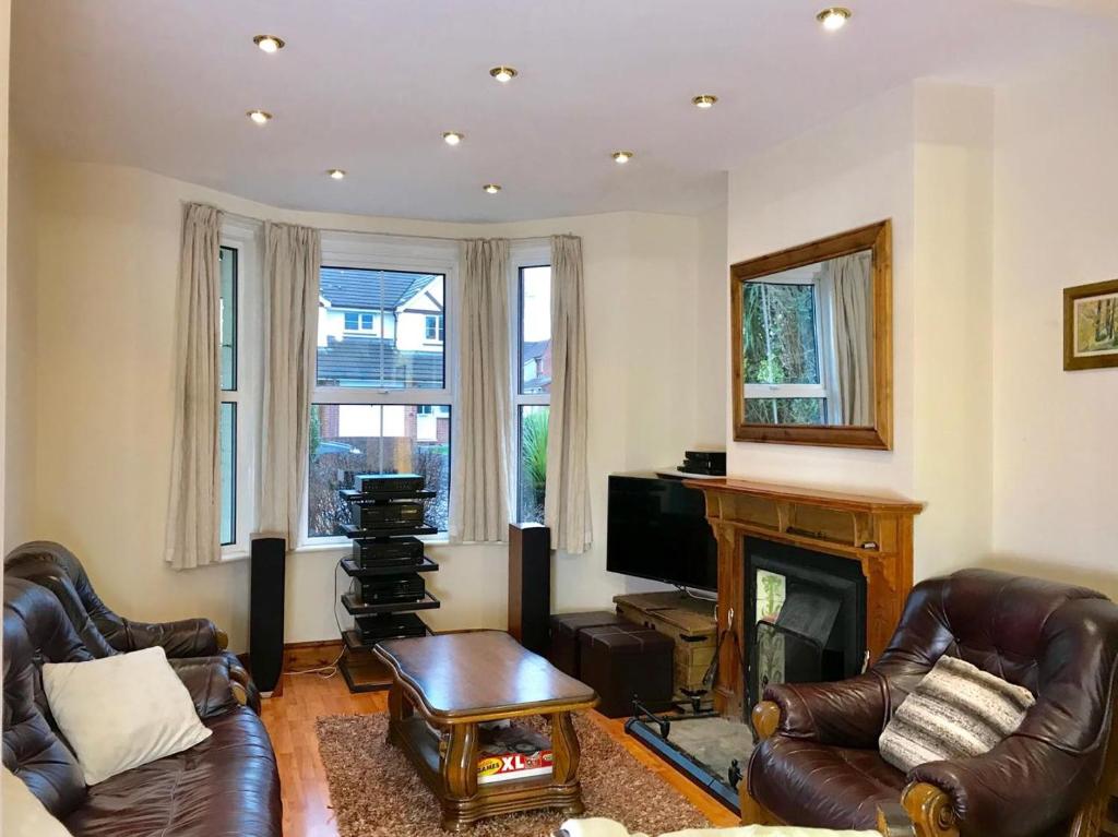 a living room with two leather chairs and a fireplace at Seaside holiday home in Exmouth