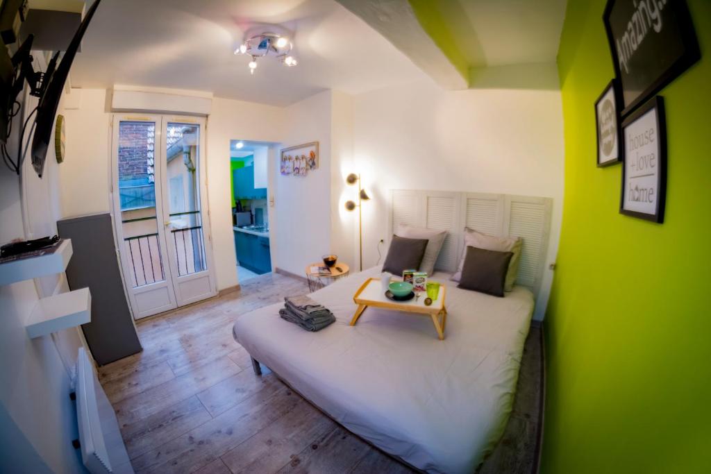 a bedroom with a white bed and a table at Appartement HYPER CENTRE avec WIFI in Troyes