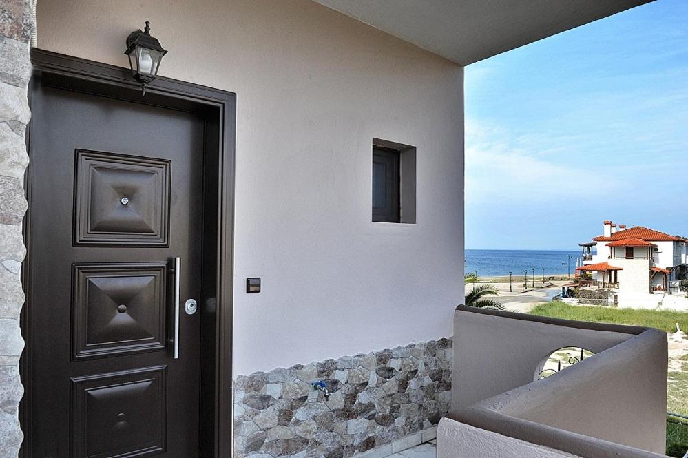 a door to a house with a view of the ocean at Palm Tree Apartments in Psakoudia