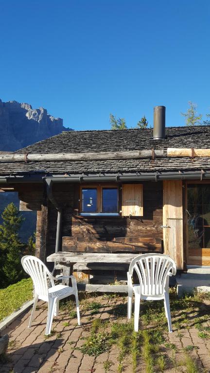 two chairs and a table in front of a cabin at Chalet Marina in Albinen