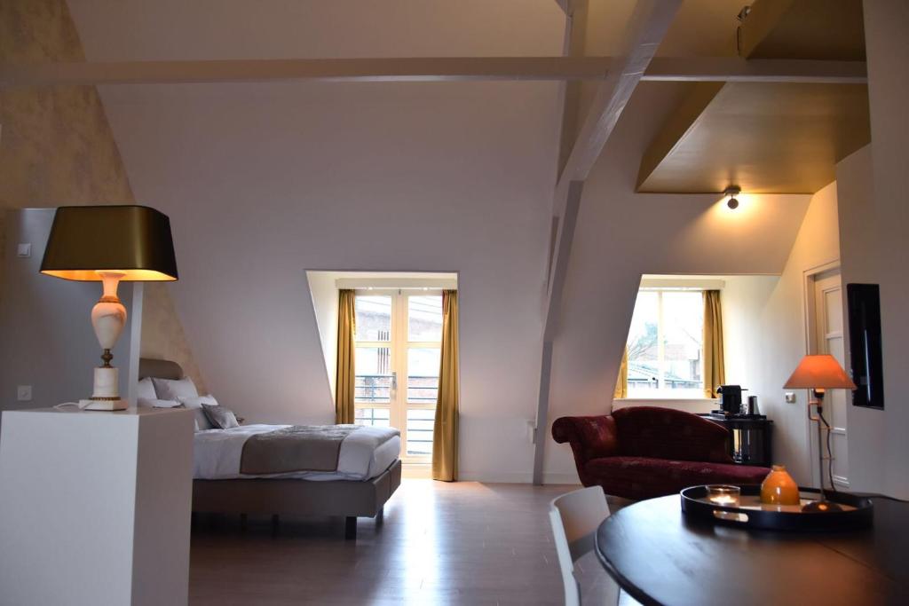 um quarto com uma cama, uma mesa e um sofá em Zzzuite25 em Oosterhout