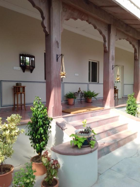 a large courtyard with potted plants and a porch at Jaswant Niwas in Jodhpur