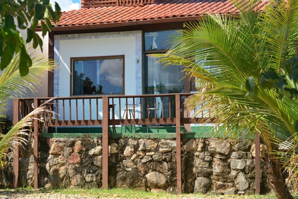 a house with a balcony on a stone wall at Tapuio Park Hotel in Cavalcante