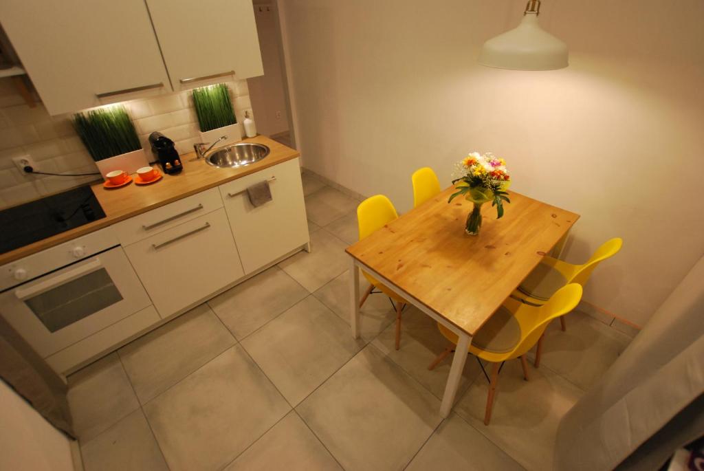 a kitchen with a wooden table and yellow chairs at Świdnicka Apartment-City Centre in Wrocław