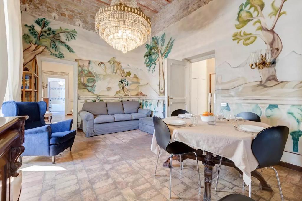 ローマにあるPalazzo Giorgioli Apartmentのリビングルーム(テーブル、椅子、ソファ付)