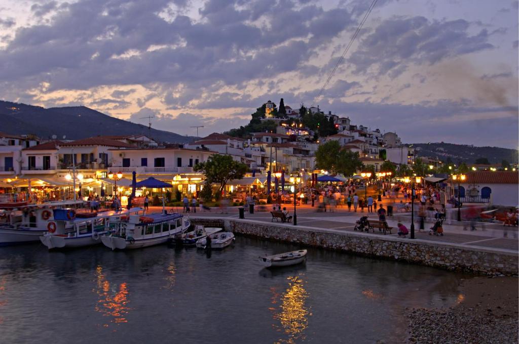 a town with boats in the water at night at Hellen Studios in Megali Ammos