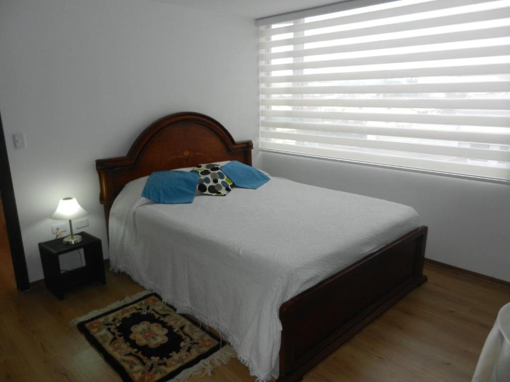 a bedroom with a large bed with a window at Suit Torre Sofia in Quito