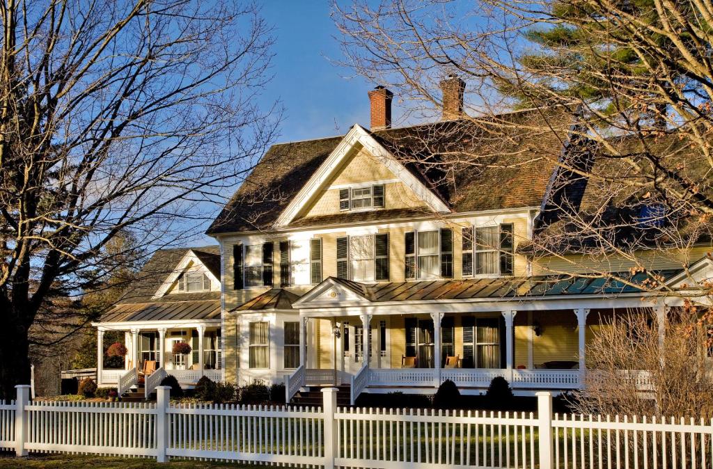 a large white house with a white fence at Jackson House Inn in Woodstock