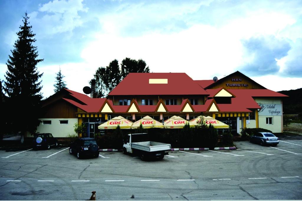 a building with a parking lot in front of it at Motel Topolog in Râmnicu Vâlcea